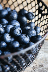 Close-up, ripe fresh blueberries in a metal basket, soft focus.