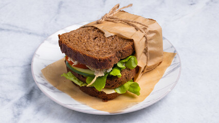Rye bread sandwich in paper isolated