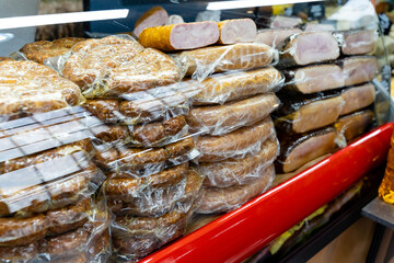 A display case that is filled with a wide variety of meats all in plastic wrap