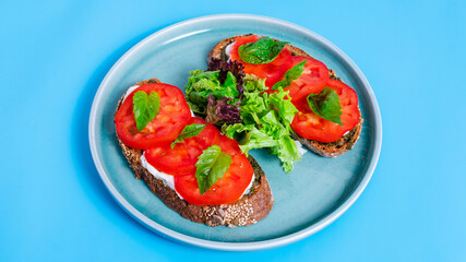 Two bruschettas with tomatoes in blue plate