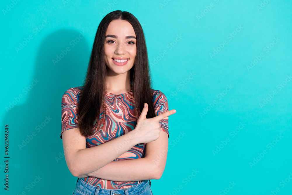 Sticker Photo of adorable lovely girl wear striped t-shirt pointing empty space isolated teal color background