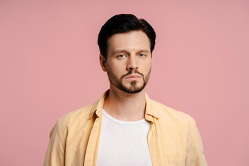 Serious bearded man looking at camera concerned isolated on pink background