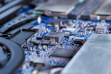 Detailed macro shot of microchips on a blue circuit board showcasing modern technology