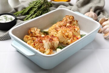 Delicious baked cauliflower steaks served on white tiled table, closeup