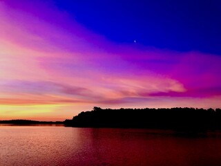 Lake sunrise beneath pink and purple clouds 
