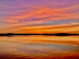 Colorful cloud ribbons at sunrise on the lake