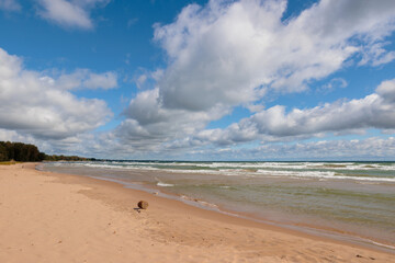 The beach is vacant as the clouds form converging lines pointing north along the shoreline of Lake Michiganat Harrington Beach State Park, Belgium, Wisconsin in early September