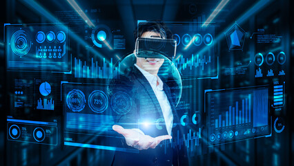 Project manager holding financial hologram while wearing VR glasses at data center. Professional business man looking and accessing at marketing data by using augmented reality technology. Ingenuity.