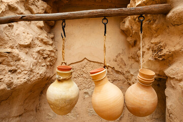 Water pottery jugs hanged in arabic citadel fortress inner yard, Nizwa, sultanate Oman