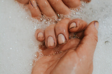 Hands of a girl after gardening with dirt under her nails who washes her hands with soap