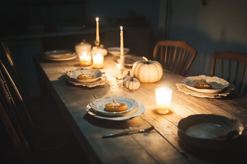 A simple rustic table set with Halloween-themed desserts, illuminated by warm candlelight, creating an eerie atmosphere with shadows casting spooky shapes, perfect for a cozy yet haunting Halloween se
