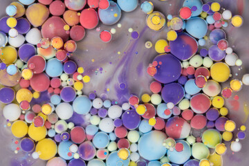 Colorful abstract arrangement of floating paint droplets on a surface creating vibrant patterns in a creative art setting