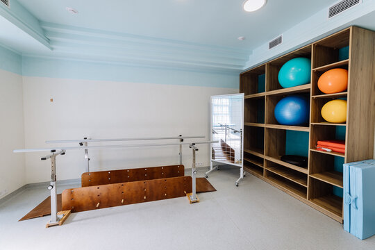 Rehabilitation equipment room with parallel bars and exercise balls for physical therapy sessions