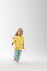 Portrait of beautiful cute little toddler girl. Child with funny face in yellow sweatshirt. Pretty smile kid in studio on white background. High quality photo