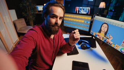 Photo editor using cellphone selfie camera to film tutorial on how to polish raw footage and apply...