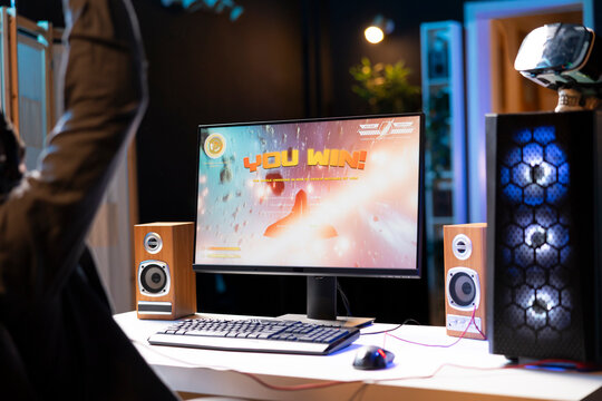 Gamer losing intense singleplayer spaceship arcade racing videogame, seeing game over screen on capable gaming computer system at home. Man being upset after being defeated on difficult game level