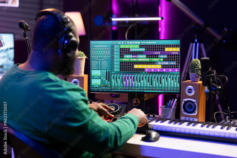 Fototapete Tracking engineer enhancing sound quality on his audio recordings, editing with mixing and mastering techniques by using a stereo console in home studio. Skilled technician adding special effects.