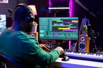 Tracking engineer enhancing sound quality on his audio recordings, editing with mixing and...