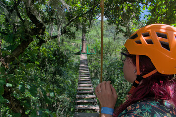 Adventurous woman in front of a suspension bridge