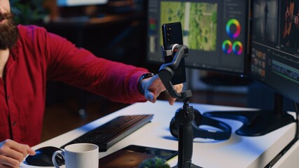 Videography content creator livestreaming using smartphone, talking with audience about elevating...