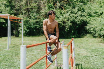 Fit and strong male sports person working out in the park doing outdoor exercises on a sunny day.