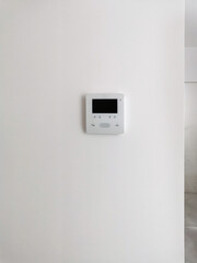Intercom with video, controller on a white background on the wall with plaster in the interior. Modern technologies, smart home, apartment and house design, video communication and broadcasting