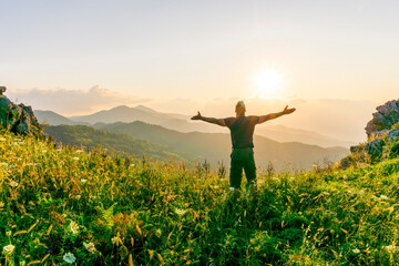 happy man watching amazing highland evening sunset, person delight with nature landscape