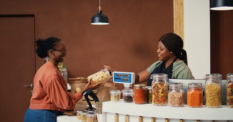 Shopper choosing pasta and spices stored in jars from grocery store, supporting eco friendly...
