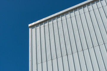 detail of an old building with corrugated like siding on a blue sky