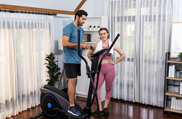 Athletic and sporty young couple or fitness buddy running on running machine together, home body workout exercise session as healthy sport lifestyle at home. Gaiety home exercise workout training.