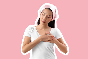 Young Asian woman on pink background. Breast cancer awareness concept
