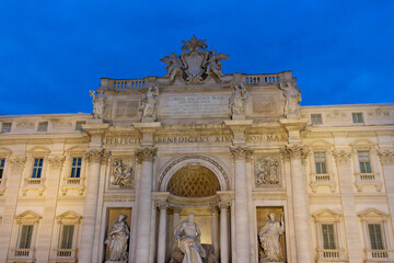 Fontana di Trevi, Rome at night, bathed in a mesmerizing glow. The grand baroque sculptures and the flowing water are dramatically illuminated, creating a stunning contrast against the deep, dark sky.