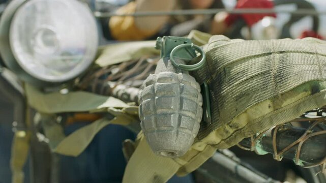 Man's hand reaching onto hood of kart and grabbing grenade - close up