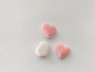 Obraz premium Pink love candy with a soft and chewy texture and sprinkled with sugar on top. on white backgrounds