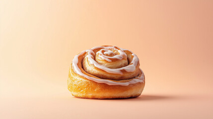 Fototapeta premium a cinnamon bun with a swirl of icing on top against an isolated pastel orange background