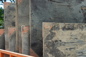 muddy wood and metal boards standing upright together at a construction site