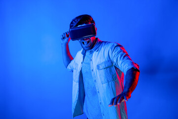 Caucasian man wearing VR glass and moving gesture holding sword. Gamer using future digital virtual reality headset or futuristic innovation to enter meta world or playing action game. Deviation.