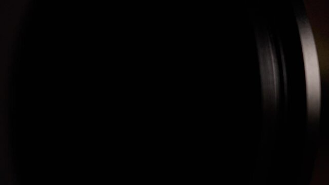 A blurry black and blue photo of a lens. The photo is dark and the lens appears to be blurry