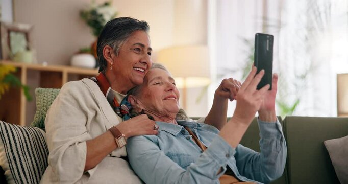Smartphone, love and mature lgbtq couple laugh together in home browsing social media or app. Gay, comedy and funny with happy lesbian women looking at memes on cellphone for fun or romantic bonding