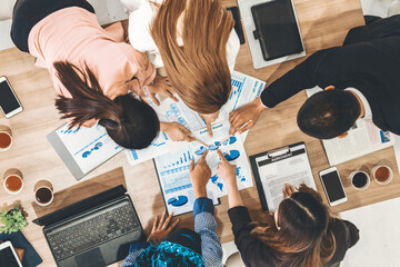 Top view of businessman executive in group meeting with other businessmen and businesswomen in modern office with laptop computer, coffee and document on table. People corporate business team uds