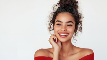 Portrait of a young woman with curly hair and a bright smile, wearing a red top.