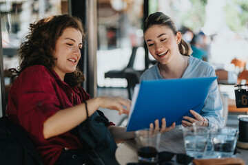 Two young business associates discussing documents and sharing ideas while working outdoors at a cafe. Professional and collaborative atmosphere.