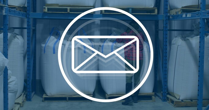 Image of envelope icon over caucasian female worker in warehouse - Powered by Adobe