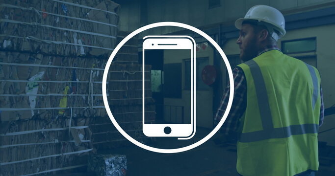Image of smartphone icon over caucasian male worker in warehouse - Powered by Adobe