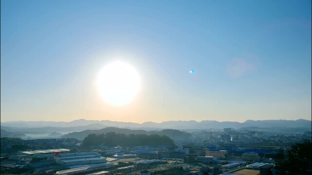 地平線から昇る朝日　和歌山県田辺市の街並み　日の出タイムラプス　太陽の光