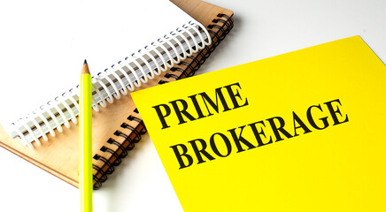 Prime brokerage concept with a yellow folder, notebooks, and a pencil on a desk