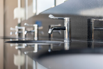 A sink with a silver faucet and a mirror above it