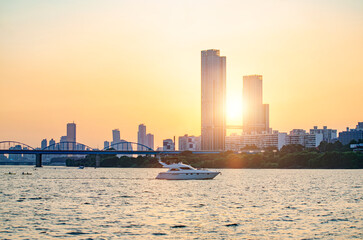 Obraz premium Sunsets behind the skyscrapers of yeouido and bridges across the Han River in Downtown Seoul, South Korea.