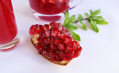 Ripe pomegranate with peel, bright red flesh, placed on a white background, together with leaves, a glass and a red water jar.

ไอคอนยืนยันโดยชุมชน
