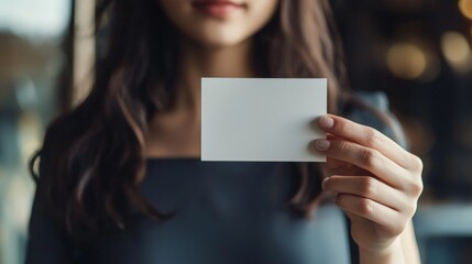 a beautiful woman holding up a blank white business card